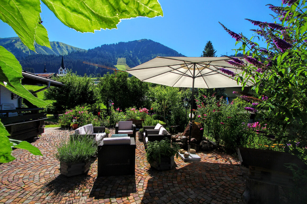 Faire Unterkunftspreise im Gästehaus Gatterhof in Riezlern Gastgarten mit Sitzgelegenheiten und Sonnenliegen